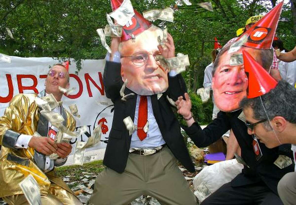 David Graeve, Keith Koski, Patt Spriggs and Jeff Grubler collect fake currency from a piñata while knocking Halliburton for its decision to open a headquarters in Dubai.
