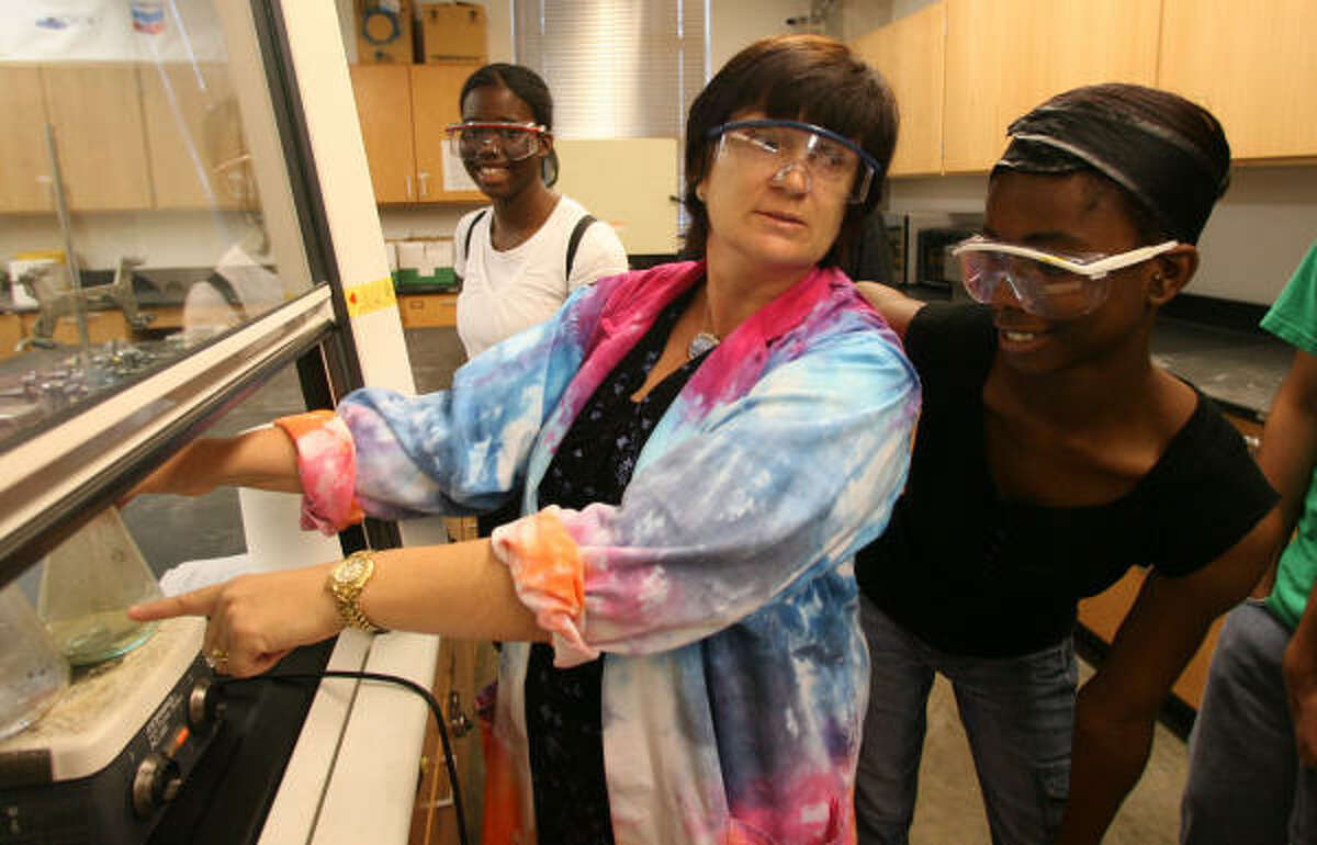Yates High School students Arieanna Onuba, background, and Toyin Onuba, right, watch Rice University's Dr. Mary McHale perform a demonstration in the nanochemistry lab.