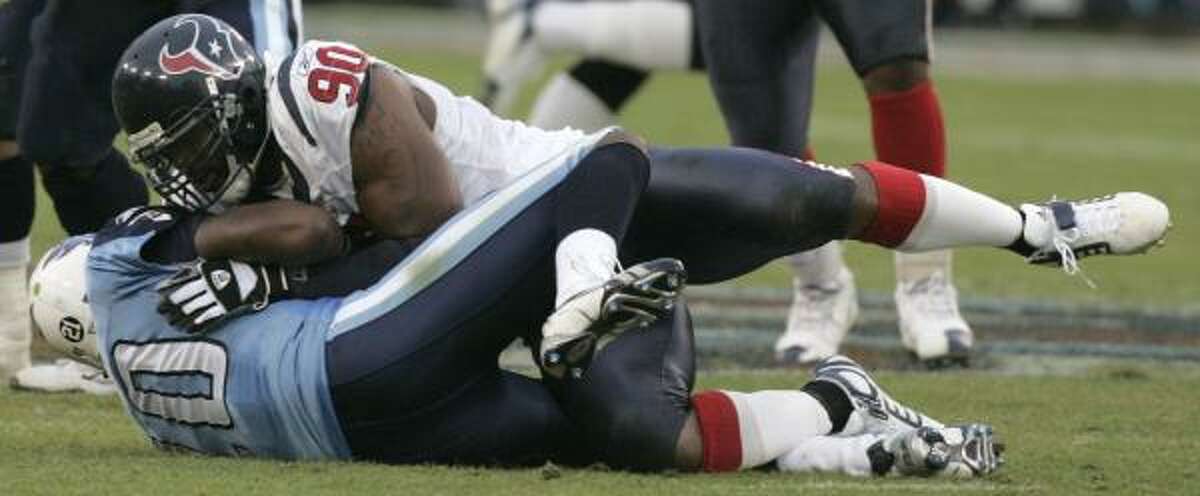 Mario Williams covers up Titans quarterback Vince Young for one of his 2 1/2 sacks Sunday, when he surpassed the Texans' single-season sacks mark.