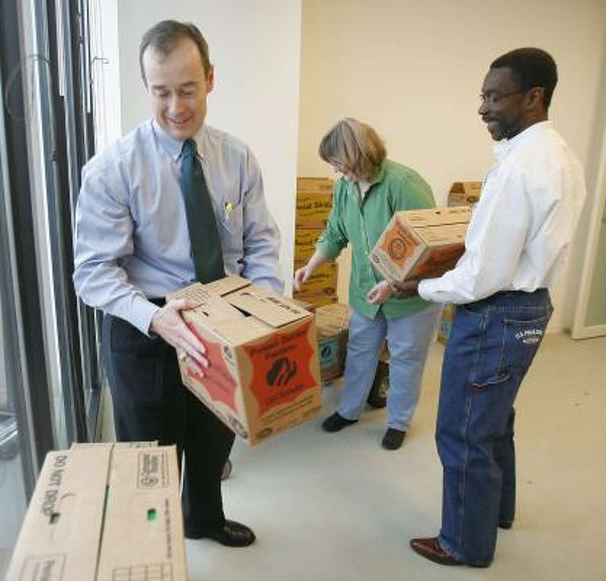 Don Jackson, left, a Haynes and Boone lawyer, unloads cases of cookies with the help of Tommy Thomas of the firm's office services and legal secretary Donene Olmstead.