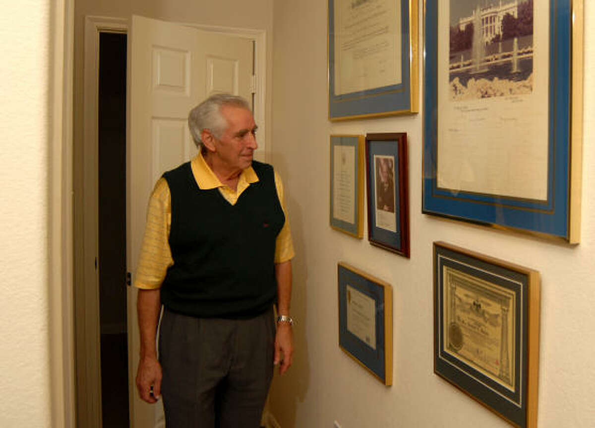 Woodlands resident Randy Woods looks at some of the memorabilia he collected when he worked at the White House during the Ford administration. He is in the hall of his home office in The Woodlands.