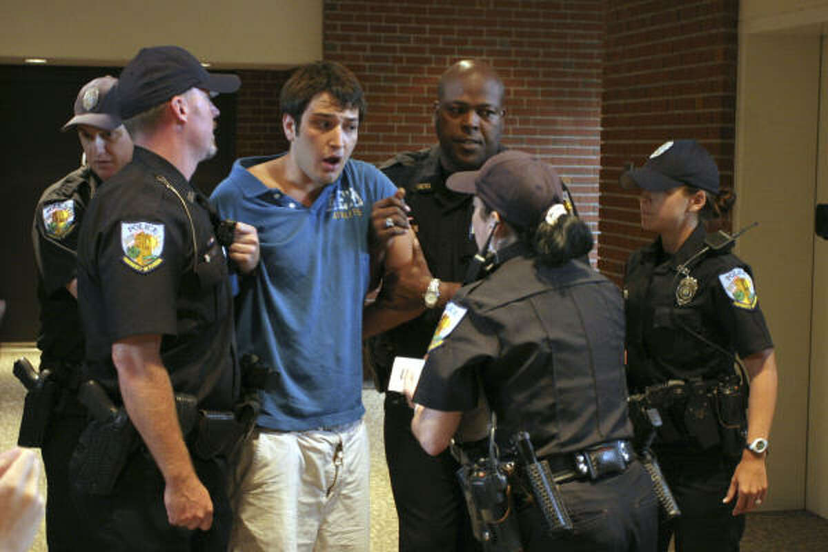 Student Andrew Meyer speaks with University of Florida police after being removed from a forum where Sen. John Kerry was speaking Monday in Gainesville, Fla.