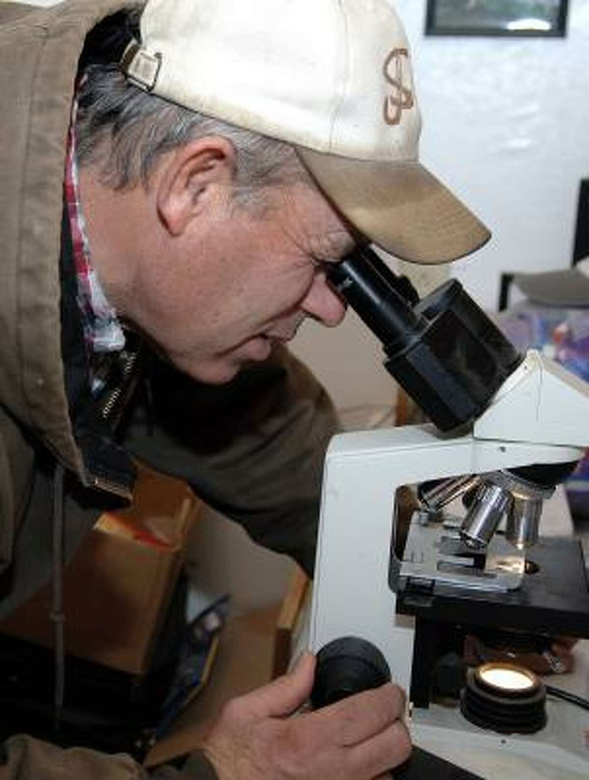 Ross Hirschfeld examines a semen sample from one of his prized boars in Benedict, Neb. News about subsidies that farmers like Hirschfeld have been getting from the federal government has raised the ire of his neighbors, but he says there are years that the subsidies have allowed him to break even.
