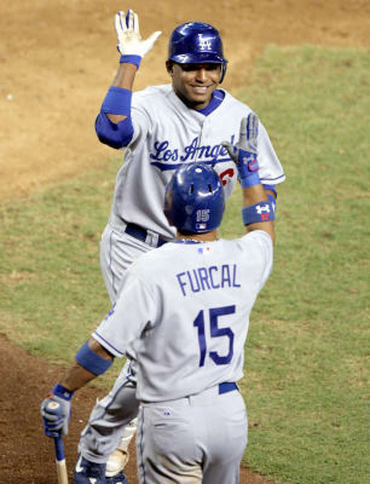 Tony Abreu, top, receives a well-deserved high-five from teammate Rafael Furcal as Abreu returns to the dugout after his first career home run -- a pinch-hit game-winner in the 10th inning -- gave Los Angeles a 6-5 victory over Arizona at Phoenix.