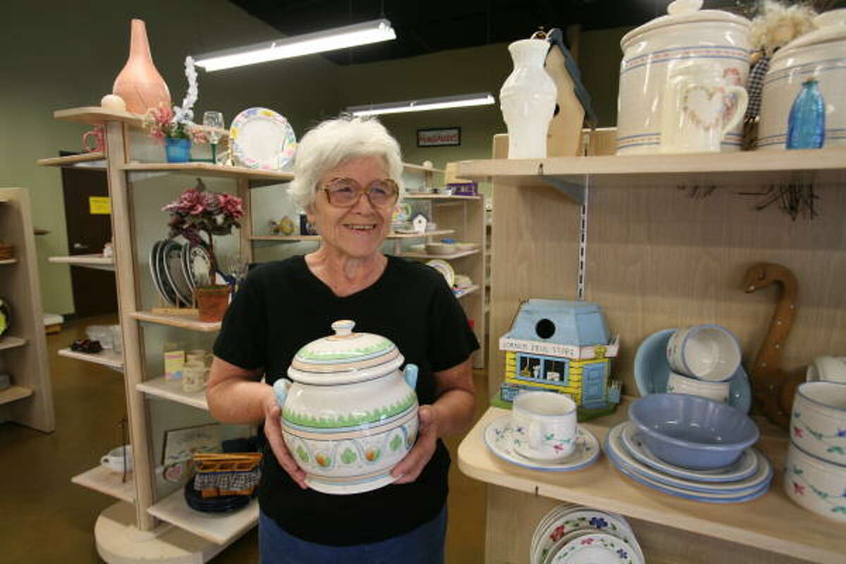 Helga Schwab, volunteer for 20 years at Bear Creek Assistance Ministries, holds a cookie jar for sale at Impact Thrift resale store.
