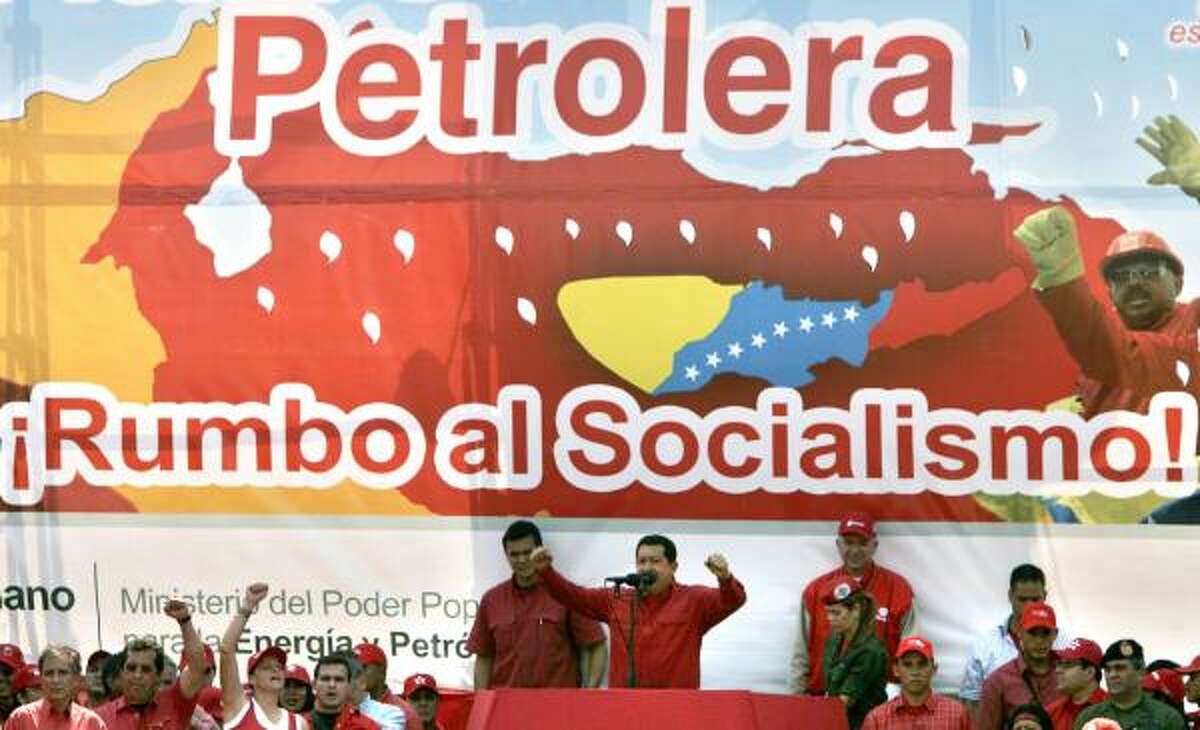 Venezuelan President Hugo Chavez delivers a speech Tuesday in Barcelona, Venezuela, with a banner as a backdrop reading, "Oil company on its way to socialism."