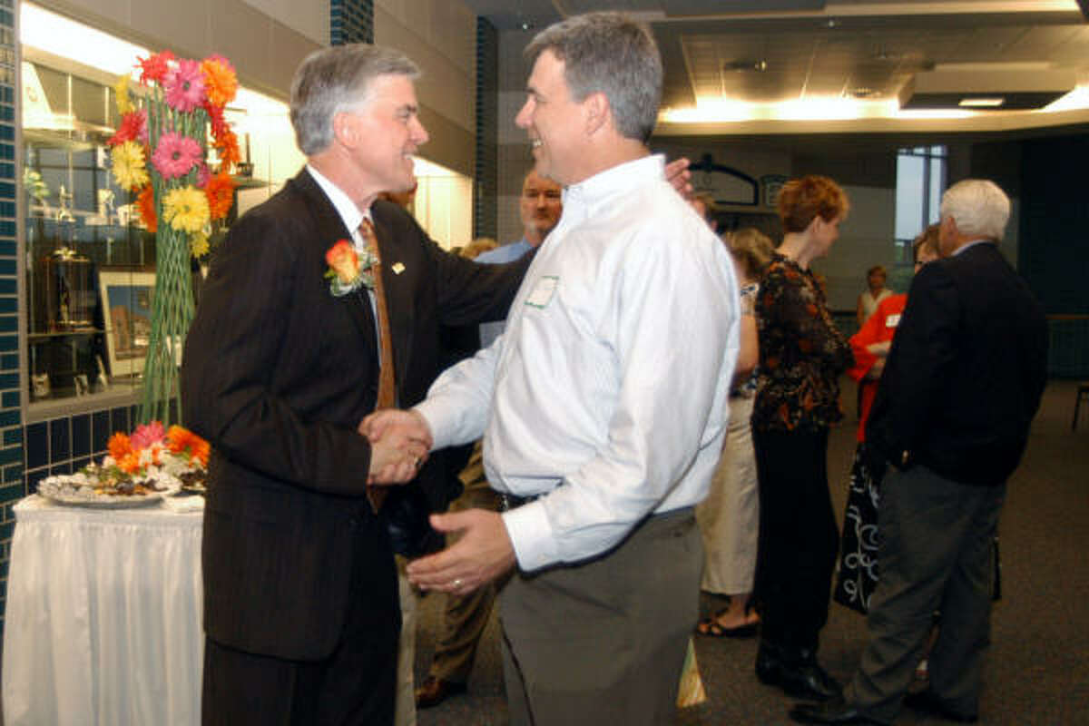 Outgoing Katy ISD Superintendent Leonard Merrell, left, shakes hands with Ken Theis during a public reception Wednesday. Both of Theis' children attended Katy schools.