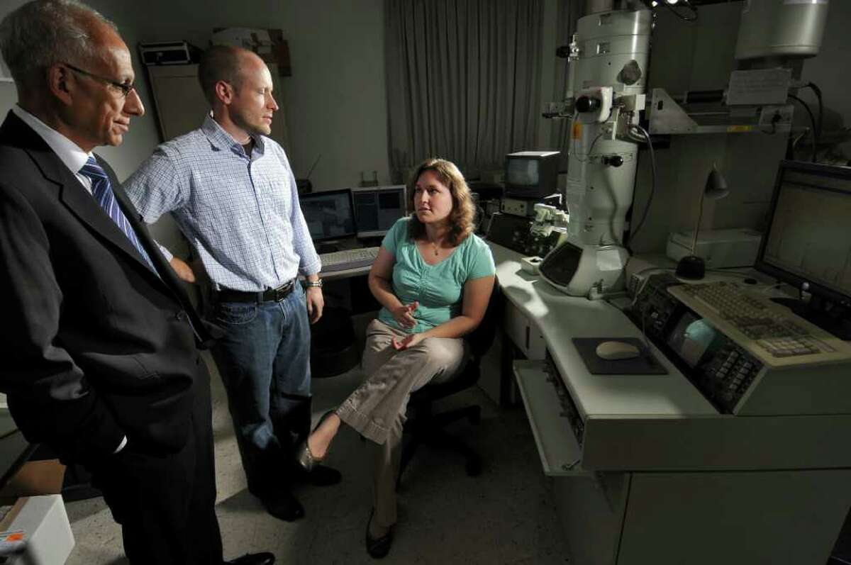 Florence Nelson, a PhD candidate at the College of Nanoscale Science and Engineering, right, talks with Chris Borst, Assistant Vice President for Module Engineering, center, and Dean Fuleihan, Executive Vice President for Strategic Partnerships, left, at a high resolution transmission electron microscope at the schoo lon Wednesday Aug. 10, 2011 in Albany, NY. Students will be hired as paid interns for a new Silicon Valley company starting operations at the Albany complex. (Philip Kamrass / Times Union)