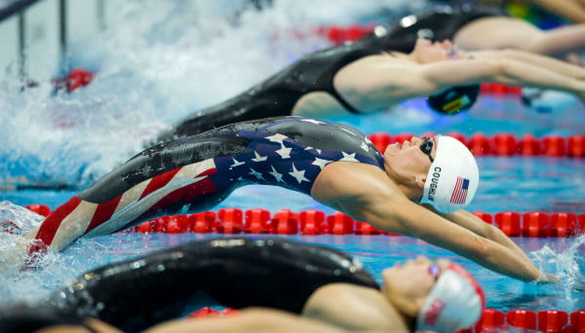 Natalie Coughlin of the United States, center, starts in the 100-meter backstroke qualifying heats on Sunday, August 8.