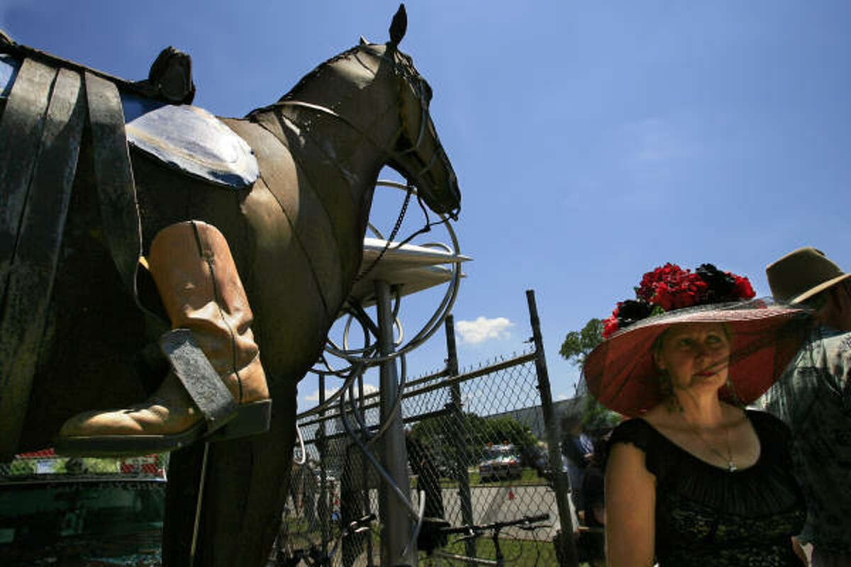 "Melanie" passes by a sculpture of a horse during a memorial for Tom Jones. The boots turned backwards in the stirrups is a military tradition when burying officers and symbolizes that the deceased died as a warrior and would ride no more.