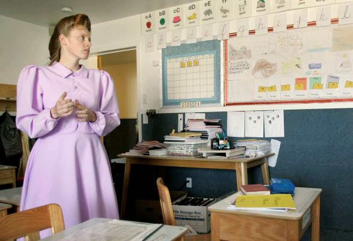 Rozie, 23, a member of the Fundamentalist Church of Jesus Christ of Latter Day Saints stands in a classroom at the school on the ranch.
