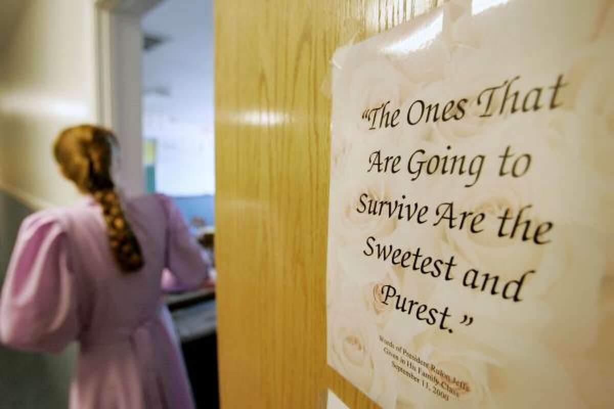 Rozie, 23, walks out of a classroom in the school on the ranch as a sign placed on the door quotes sect leader Rulon Jeffs on April 16
