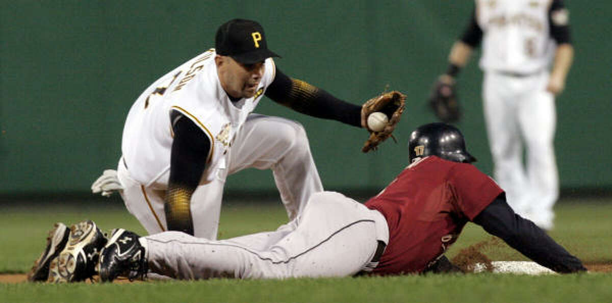 Lance Berkman dives back to second as Pirates shortstop Jack Wilson tries to tag him out in the first inning.
