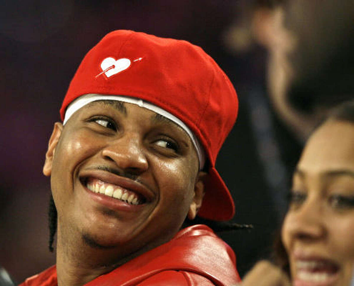 Nuggets forward Carmelo Anthony laughs as he watches the Rookie Challenge from the sidelines.