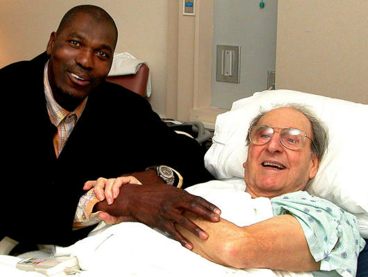 Toronto Raptors' Hakeem Olajuwon, right, hugs his former coach