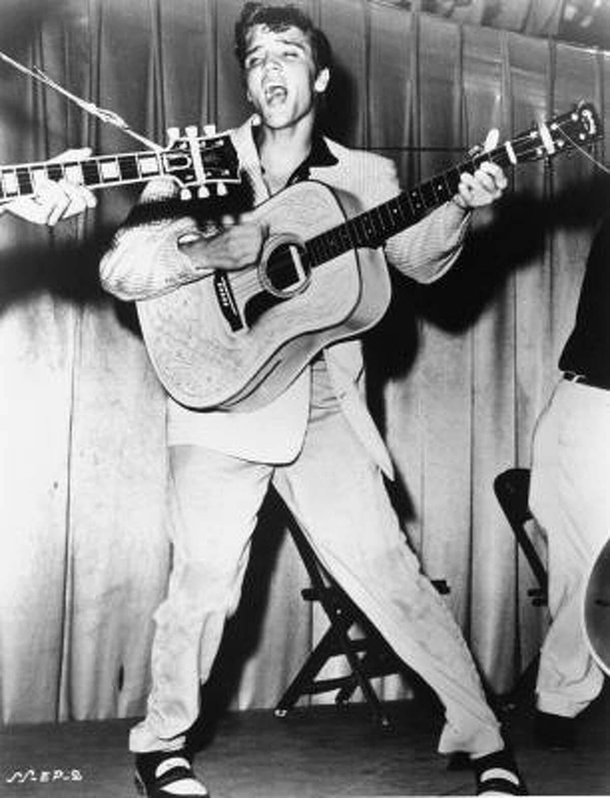 This is a 1956 file photo, originally supplied by RCA Victor, shows Elvis Presley performing. This photo was used for his first RCA Victor album cover.