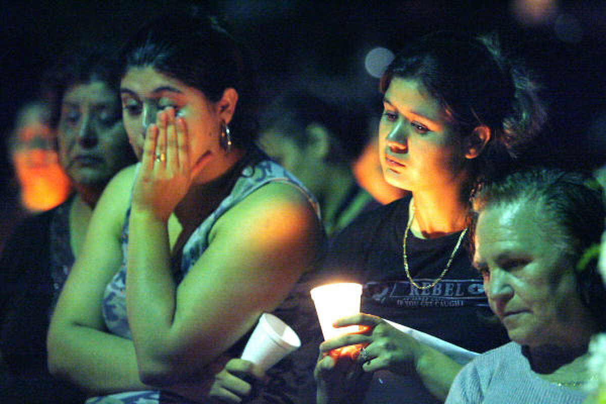 Rosa Rios, center, mother of 4-year-old Pedro Rios Jr., holds a candle during a vigil held by neighbors and friends. With her are Flor Borrego, left, aunt of Pedro Rios and Pedro's grandmother, Erminia Rios, right. Pedro died last week after two pit bulls attacked him while he was playing near his home.