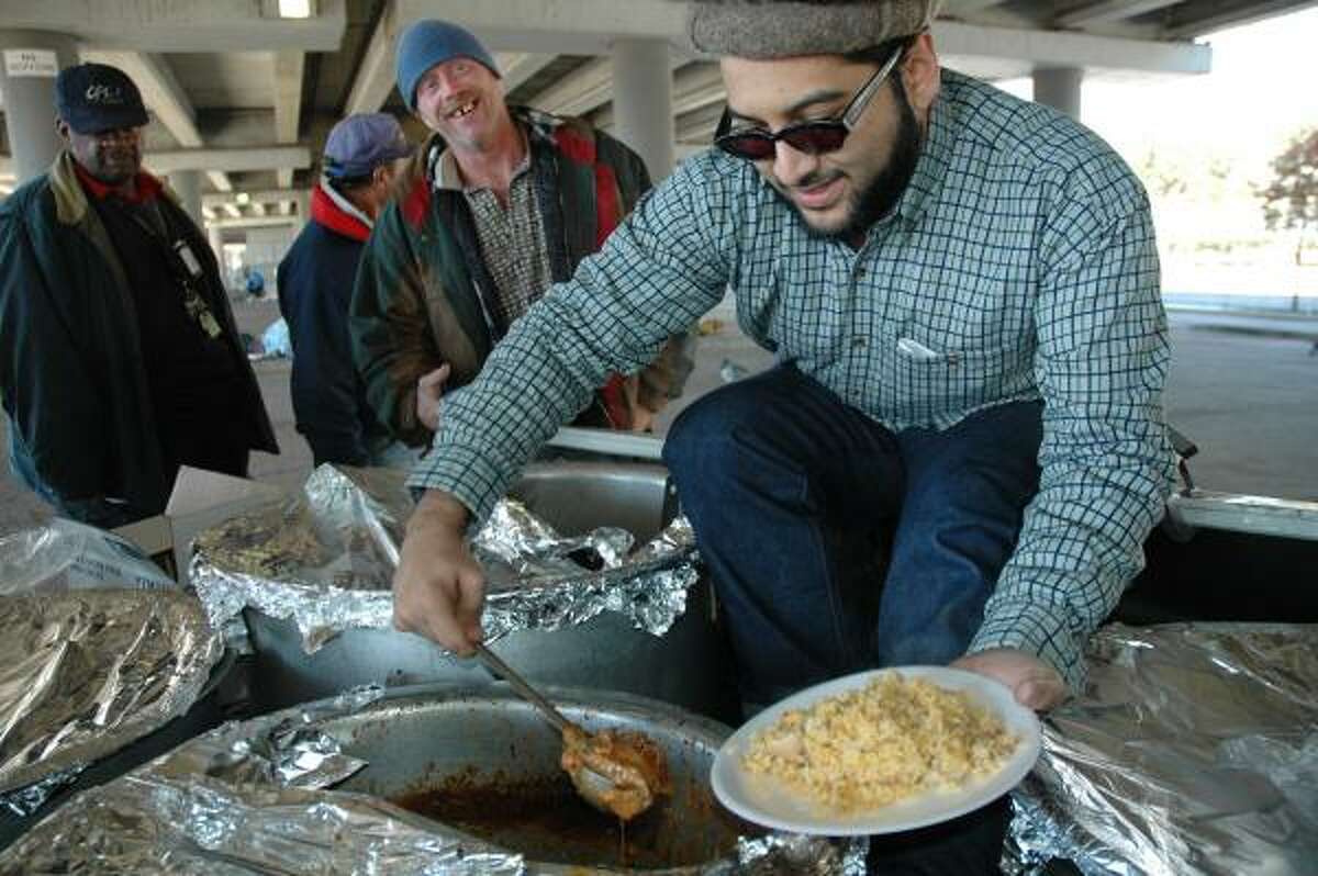 Accused Taliban supporter Adnan Mirza, a Pakistani national who was in the U.S. on a student visa, is shown serving Christmas Day dinner to Houston homeless men in 2004.