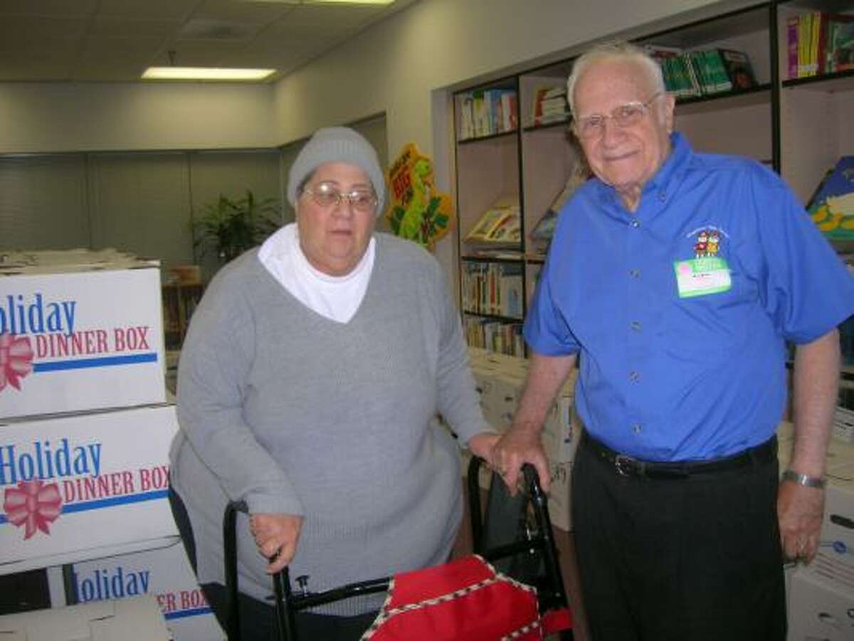Houston Community Service Club members Elaine Clarke, left, and Harold Goldstein unloaded boxes containing turkeys and ingredients for Thanksgiving meals for about 100 families of pupils who attend Halpin Early Children Center, 10901 Sandpiper Drive. Clarke and her husband started the club in 2001.