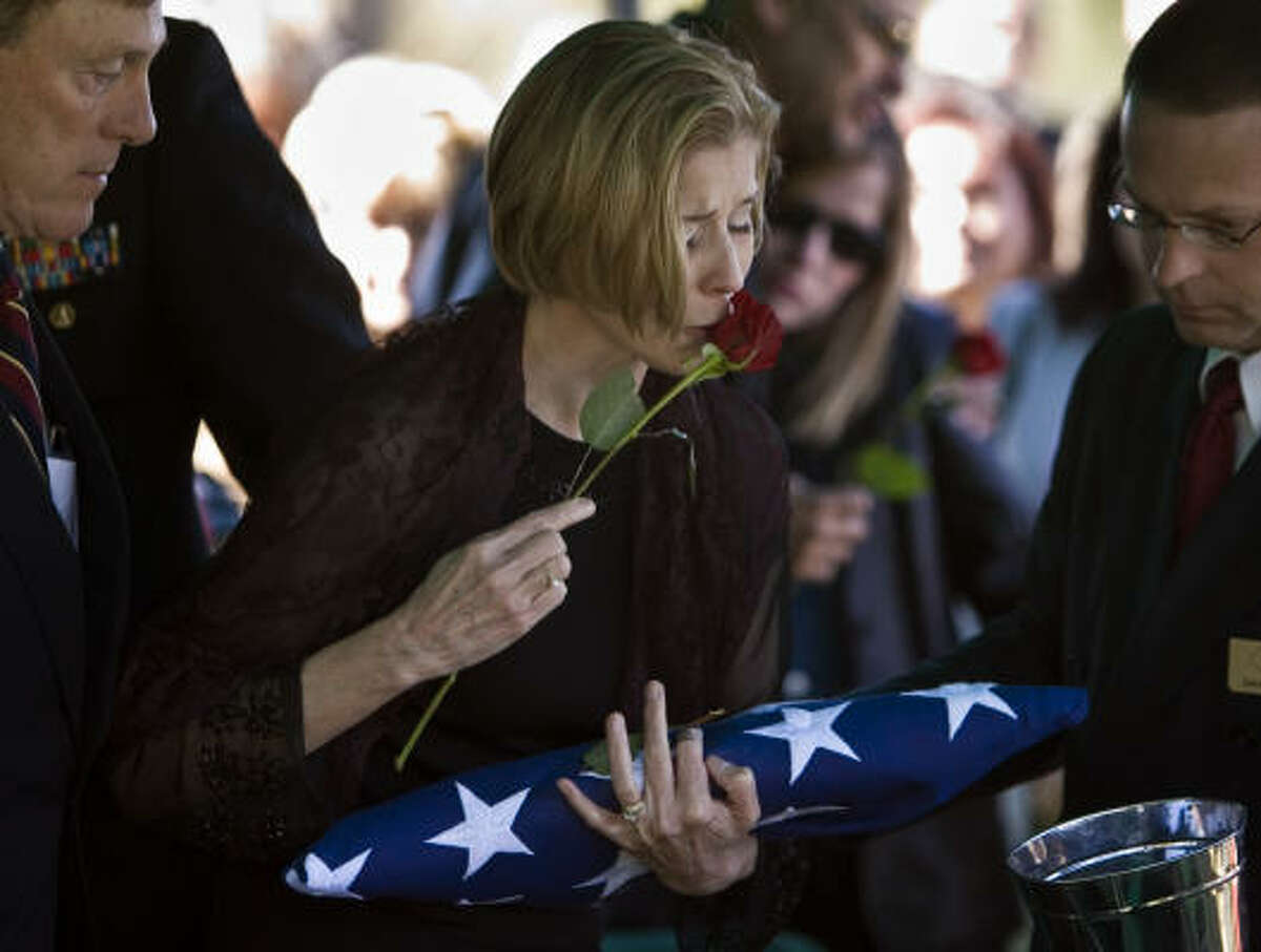 Feb. 18, 2007: Lilia Carr clutches a flag as she kisses a rose before tossing it into the grave of her son, US Marine Sgt. James R. Tijerina, who graduated from Katy High School, died in Iraq on Feb. 7.