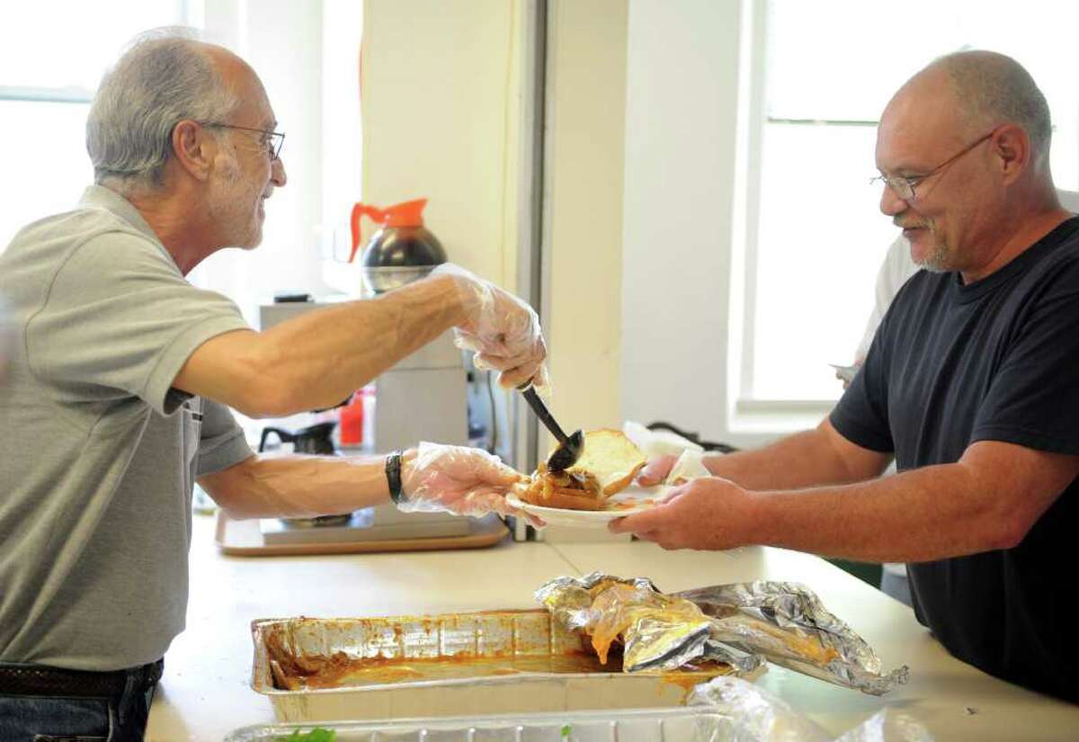 John Porto, clinical director at Homes for the Brave, serves dinner to Navy veteran Jeff Belanger Wednesday, July 27, 2011 at the organization in Bridgeport, Conn.