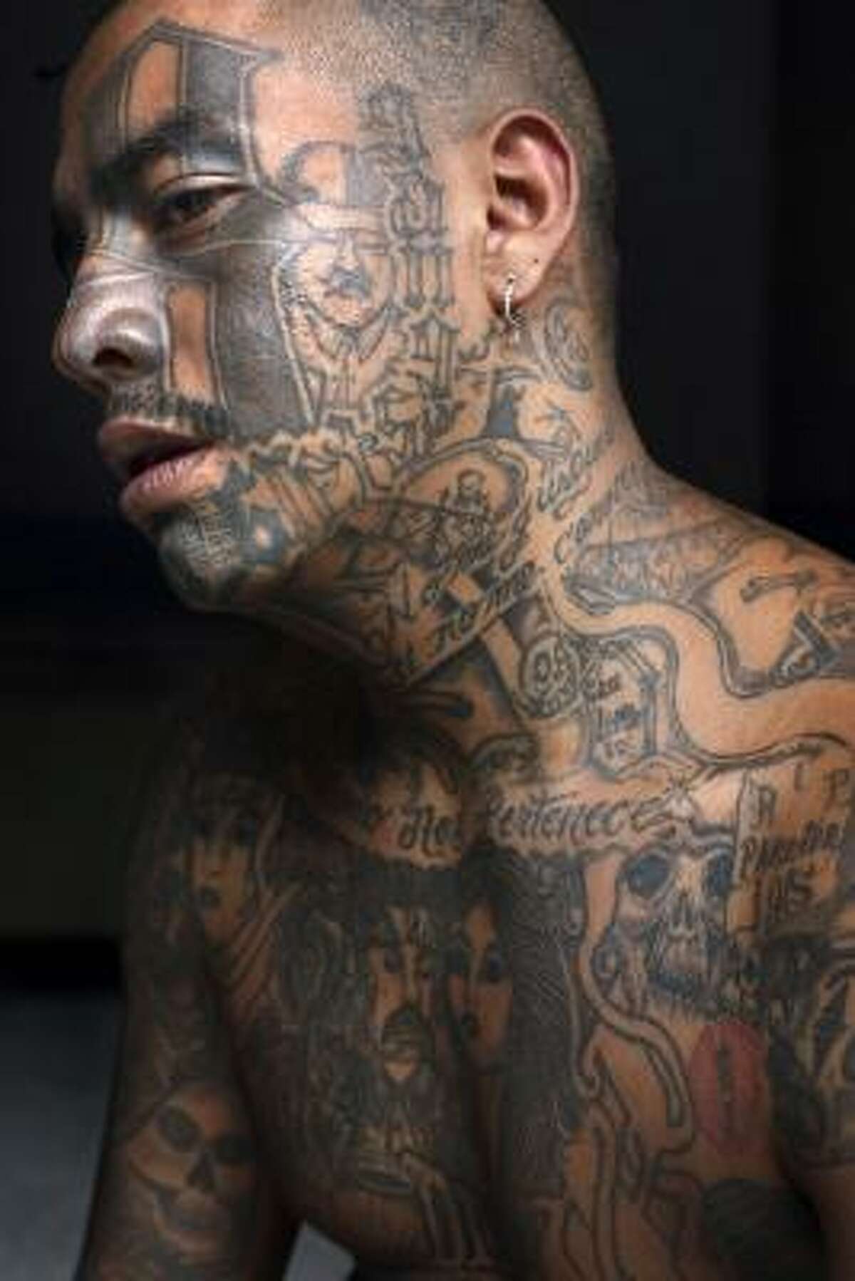 A Mara gang member who identifies himself as "Smoking," 25, poses for his portrait in prison in Chimaltenango, Guatemala, in this Oct. 19 file photo. After anti-gang laws were approved in Honduras and El Salvador, and a string of killings in Guatemala committed by neighbors and security forces, gang members have stopped tattooing themselves.