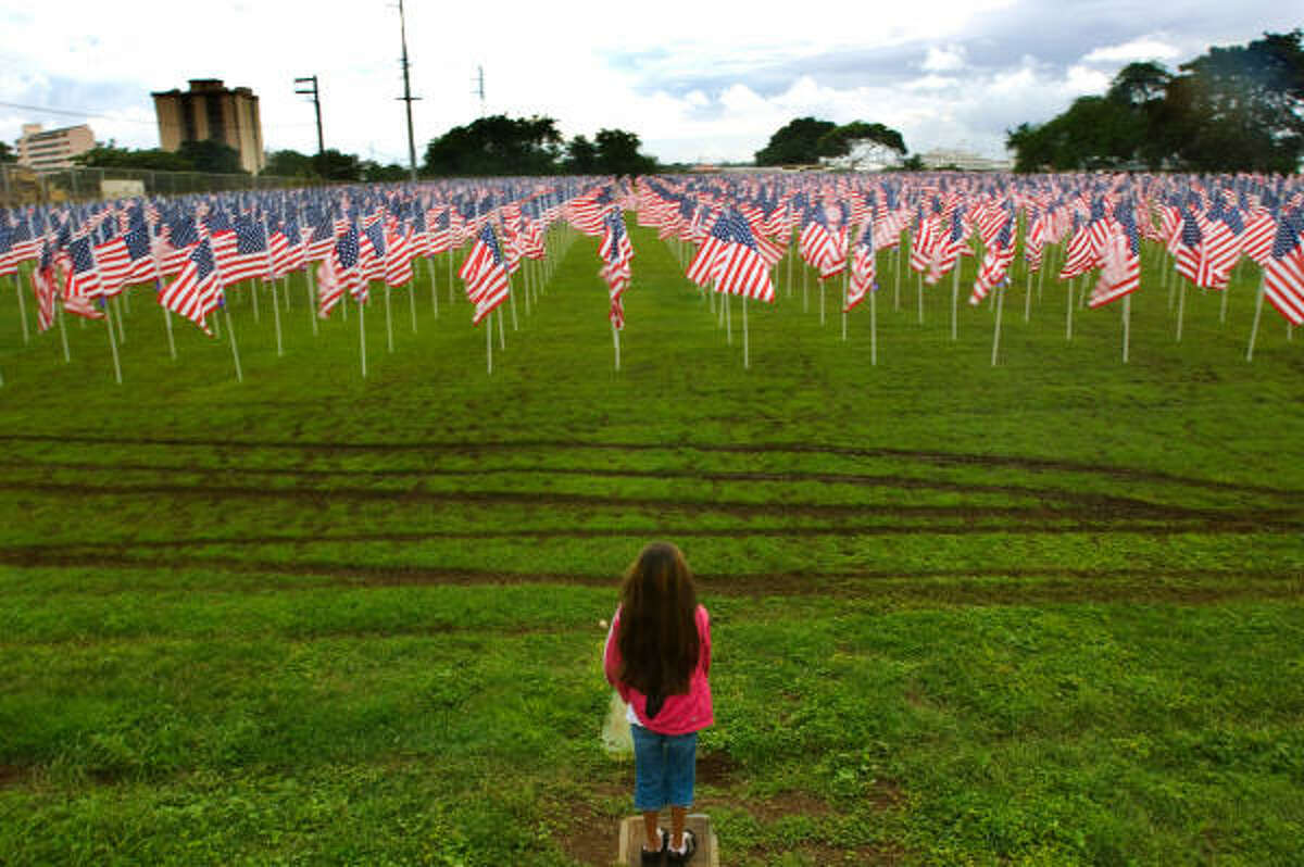 Alyssah Ruff, 9, of Pearl Harbor, Hawaii stands near the edge of the "Healing Field", a memorial of 2,500 flags over looking the Arizona Memorial during the commemoration marking the 66th anniversary of the Pearl Harbor attack.