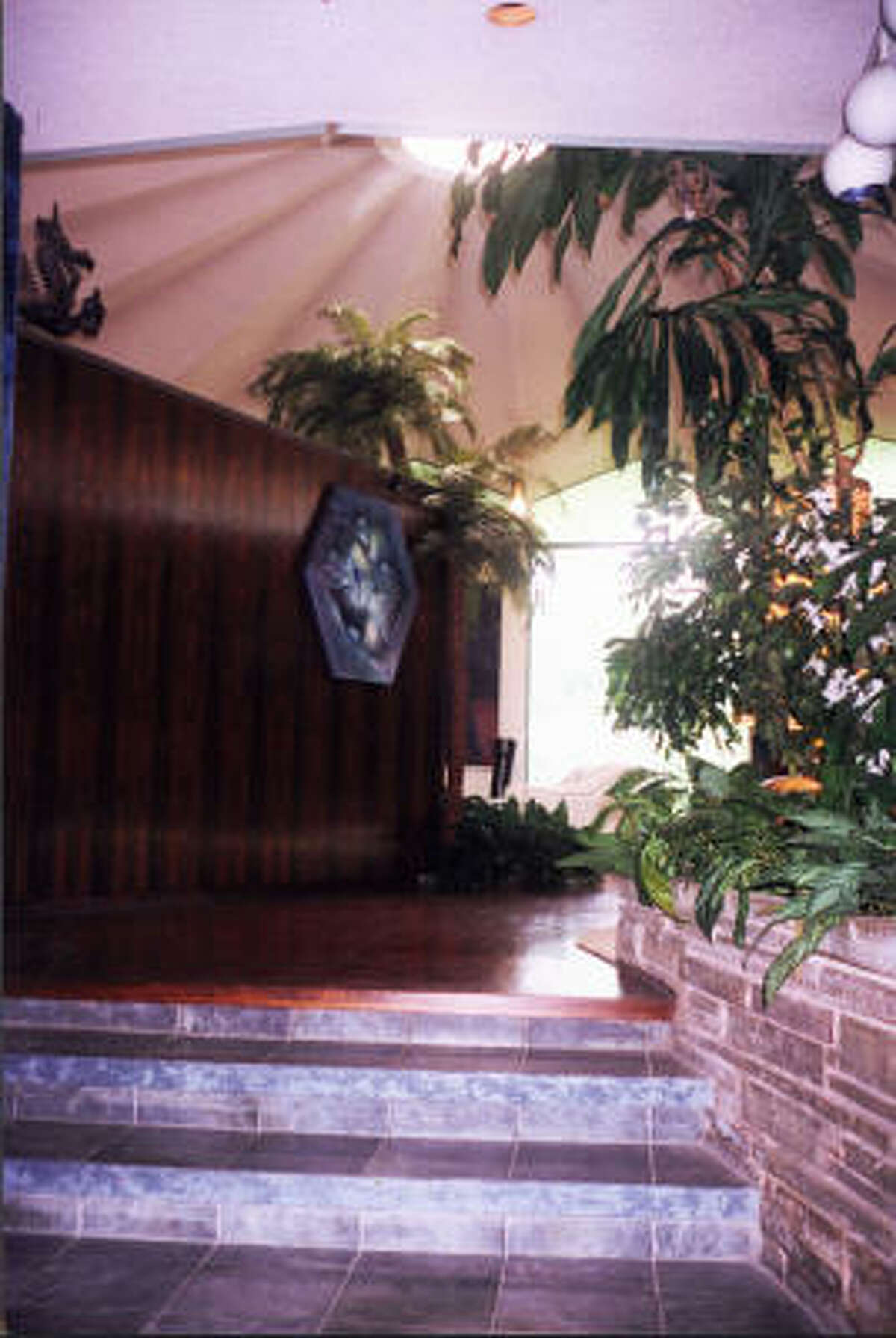 The entry way to the Cohen's contemporary home built in 1964. A rosewood divider wall and a skylight are visible from the entry.