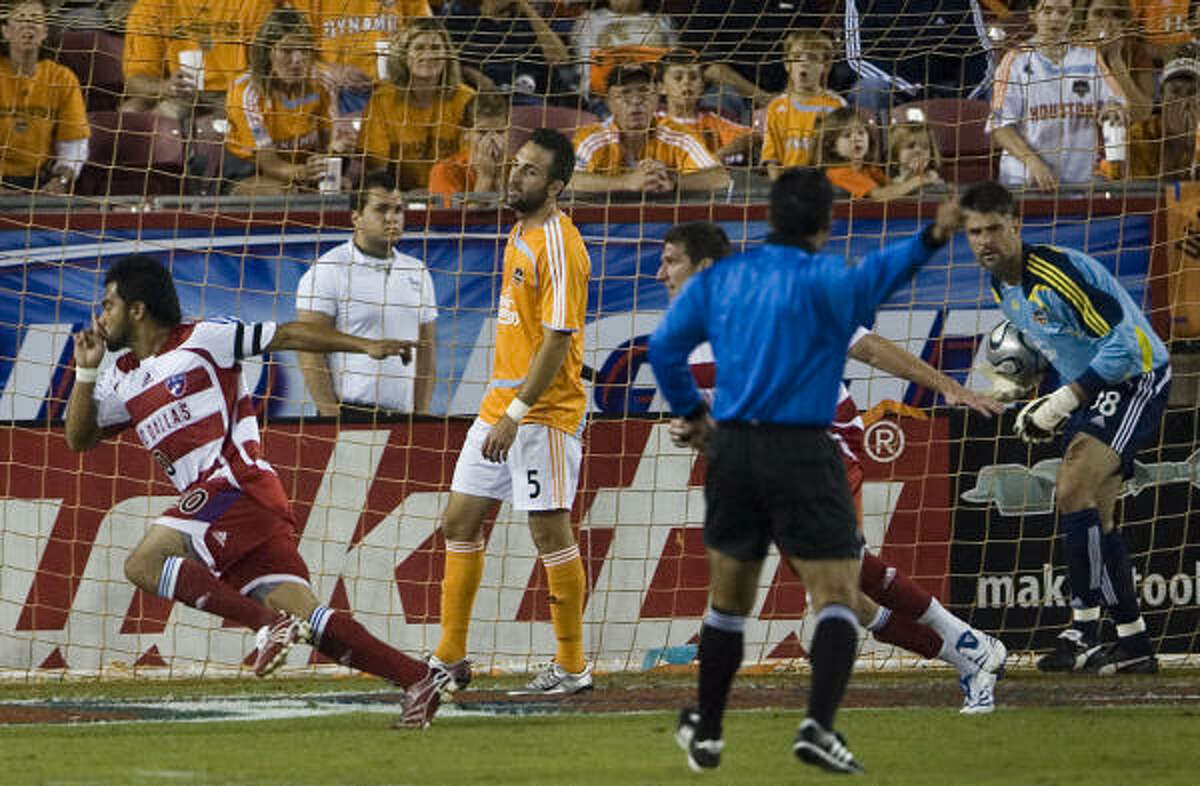 FC Dallas' Carlos Ruiz , left, celebrates after beating Houston Dynamo goalkeeper Pat Onstad, right, for a goal in the 14th minute in MLS soccer playoff action.