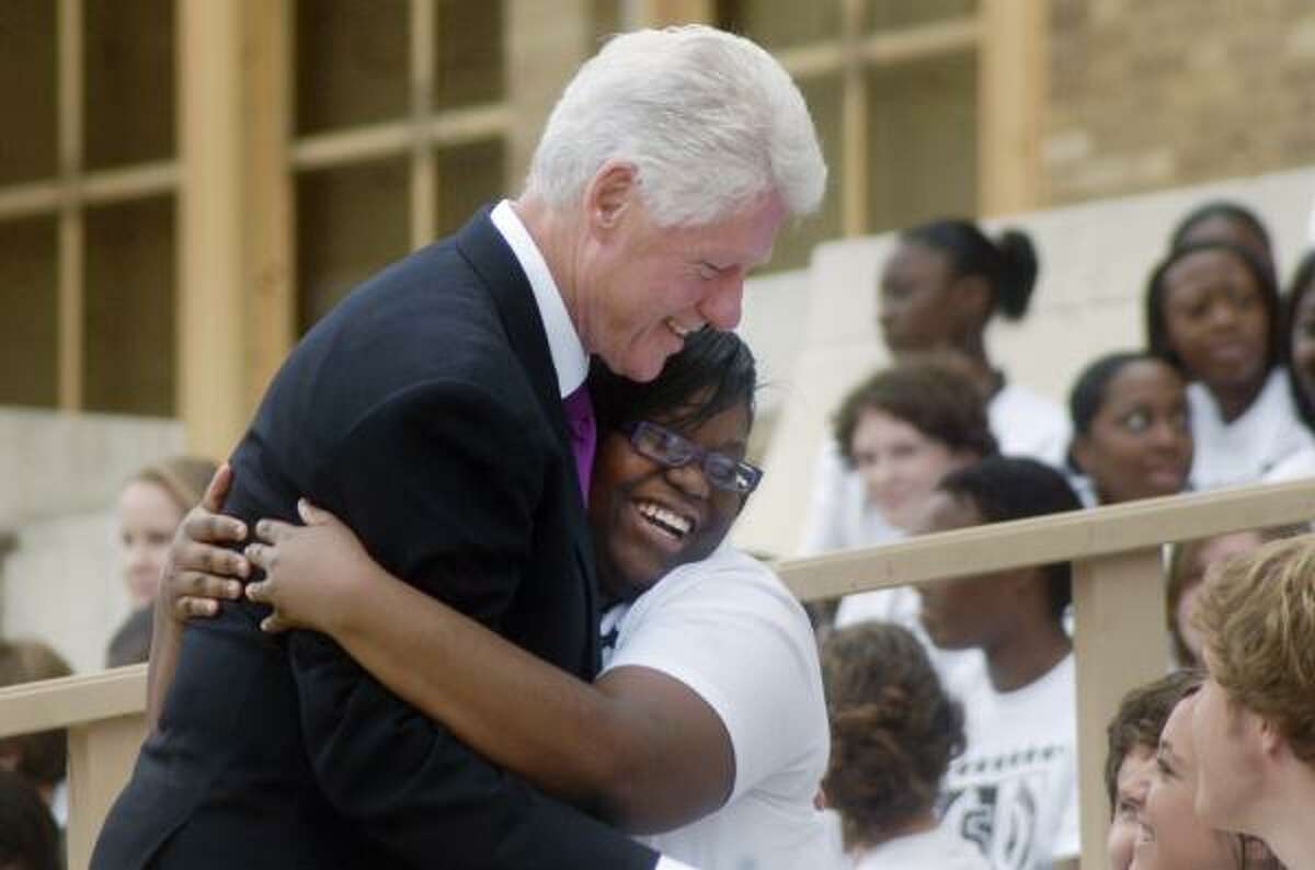 Former President Bill Clinton gets a hug from an unidentified Little Rock Central High School student Tuesday during 50th anniversary observances of the school's integration in Little Rock, Ark.