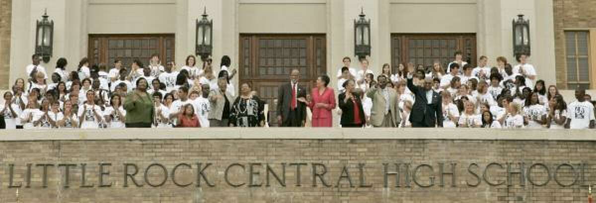 The Little Rock Nine — Melba Patillo Beals, Thelma Mothershed Wair, Minnijean Brown Trickey, Elizabeth Eckford, Terrence Roberts, Carlotta Wallls LaNier, Gloria Ray Karlmark, Jefferson Thomas and Ernest Green — wave as they are applauded by Little Rock Central High School students.
