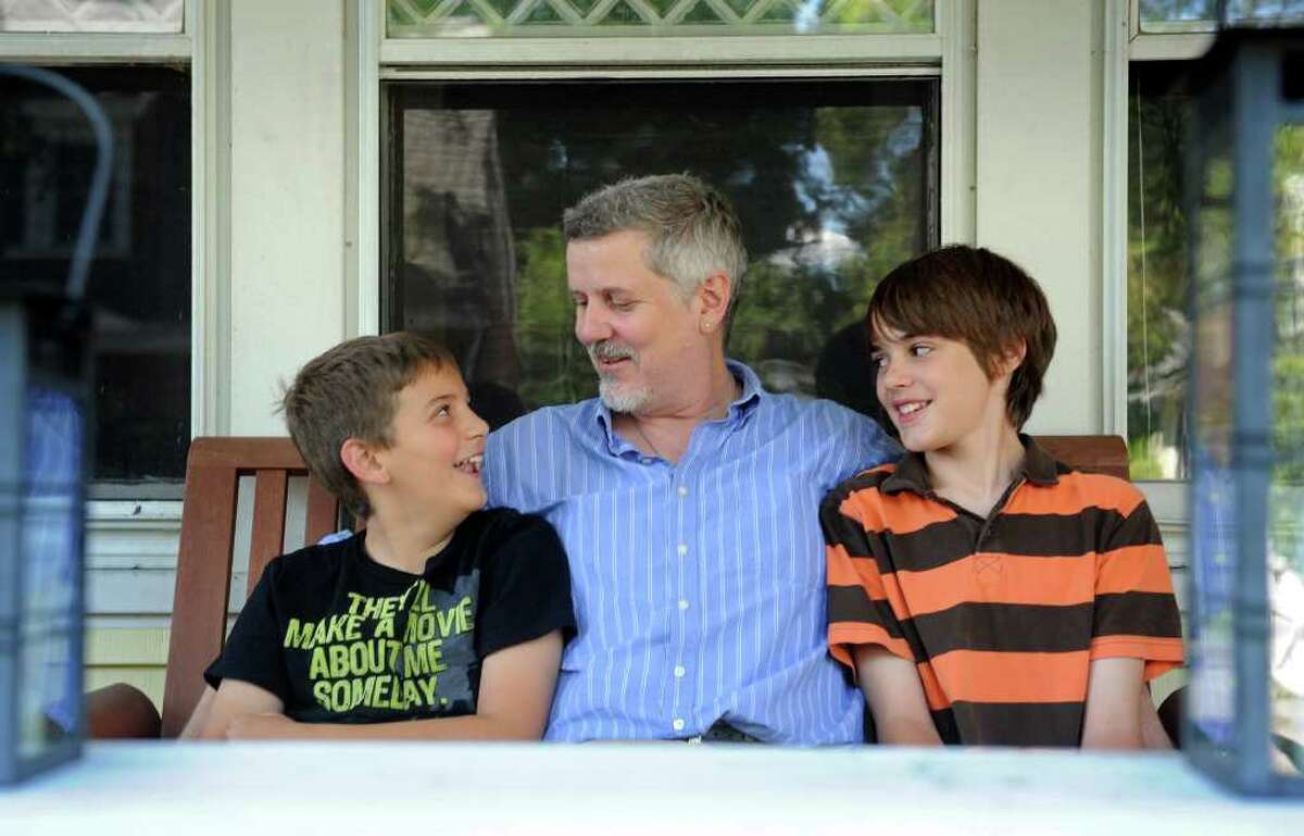Matthew Abourezk and his sons, Zachary, 10, left, and Liam, 13, sit on the front porch of their Darien home Friday, August 12, 2011. Abourezk has shared custody of his children and is among a growing number of single dads in Fairfield County.