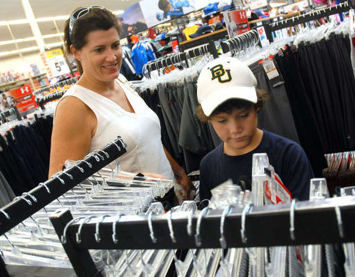 Elizabeth Bunk and her son Foley, 10, shop for school clothes at Academy on the Southwest Freeway.