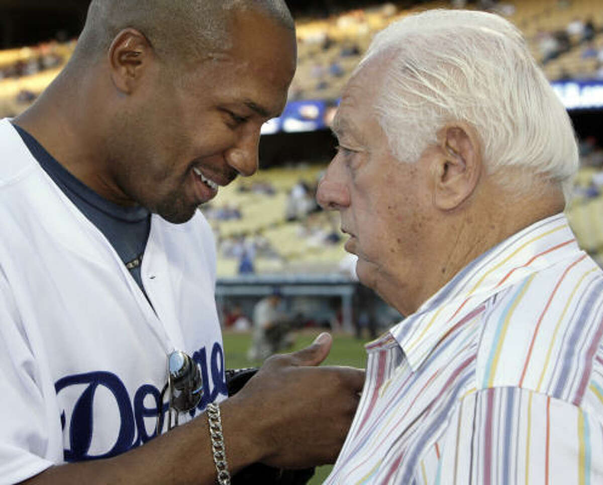 The Los Angeles Lakers' Derek Fisher, left, chats with former Dodgers manager Tommy Lasorda before throwing out the ceremonial first pitch.