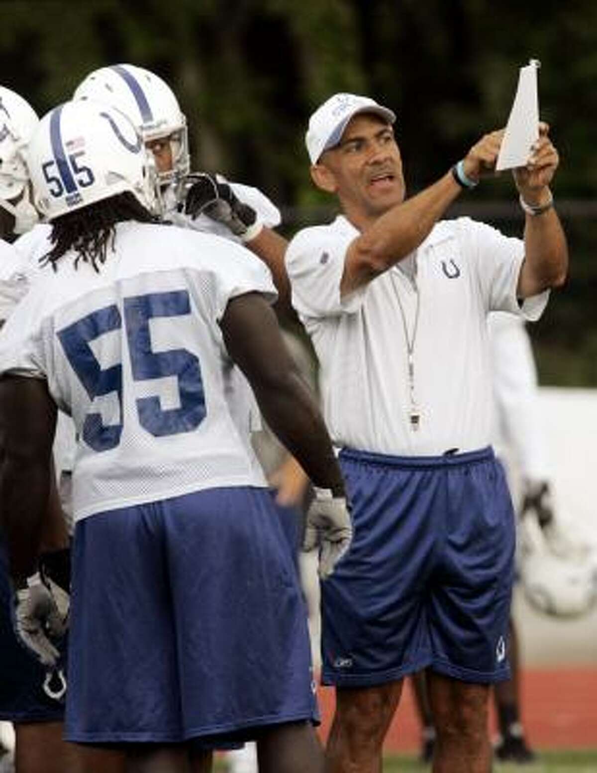 COLTS (Terre Haute, Ind.): Coach Tony Dungy, right, goes over a play with linebacker Clint Session (55) and other players during practice.