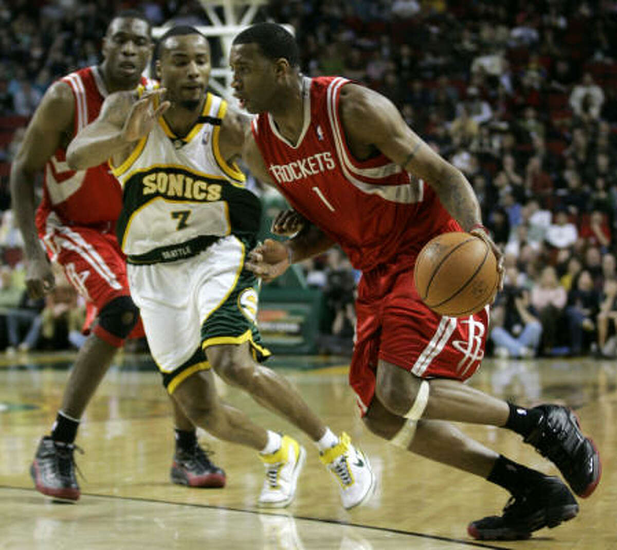 Rockets guard Tracy McGrady, right, takes the ball around SuperSonics forward Rashard Lewis in the first quarter.