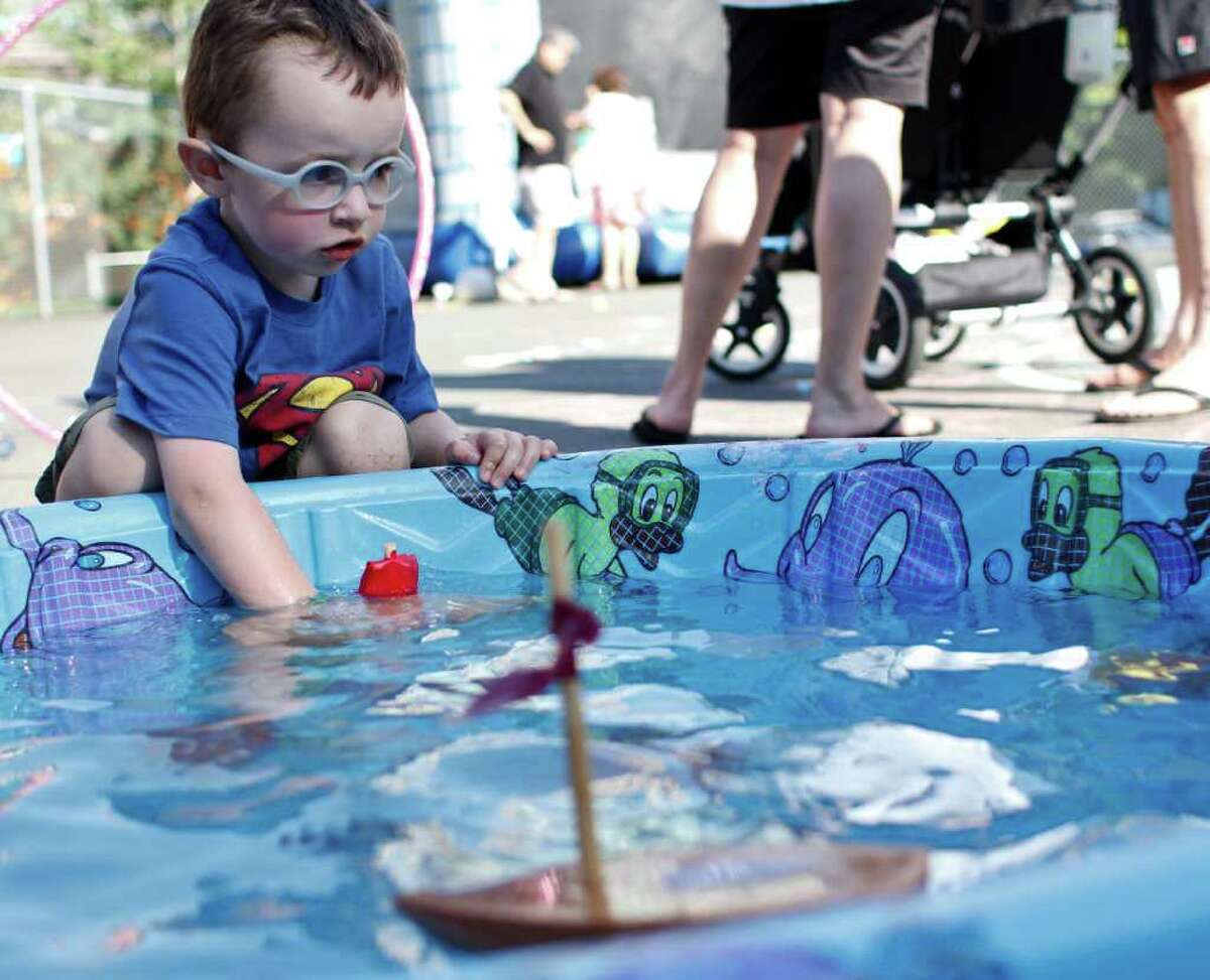 Jay Matthew, 3, plays with his own handmade toy boat at the South Lake Union Block Party on Denny Way and Westlake Avenue in Seattle on Friday, August 12, 2011.