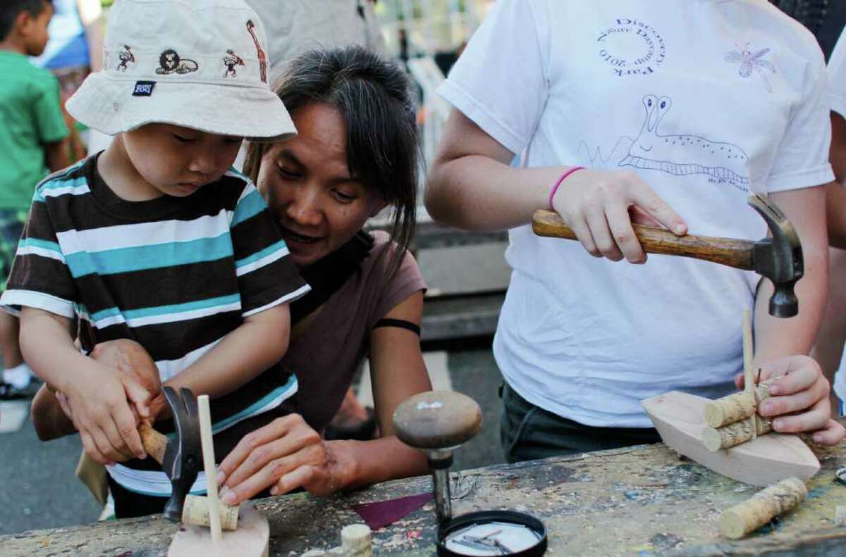 Phi Nguyen and her nephew Miles Nguyen build a wooden boat.