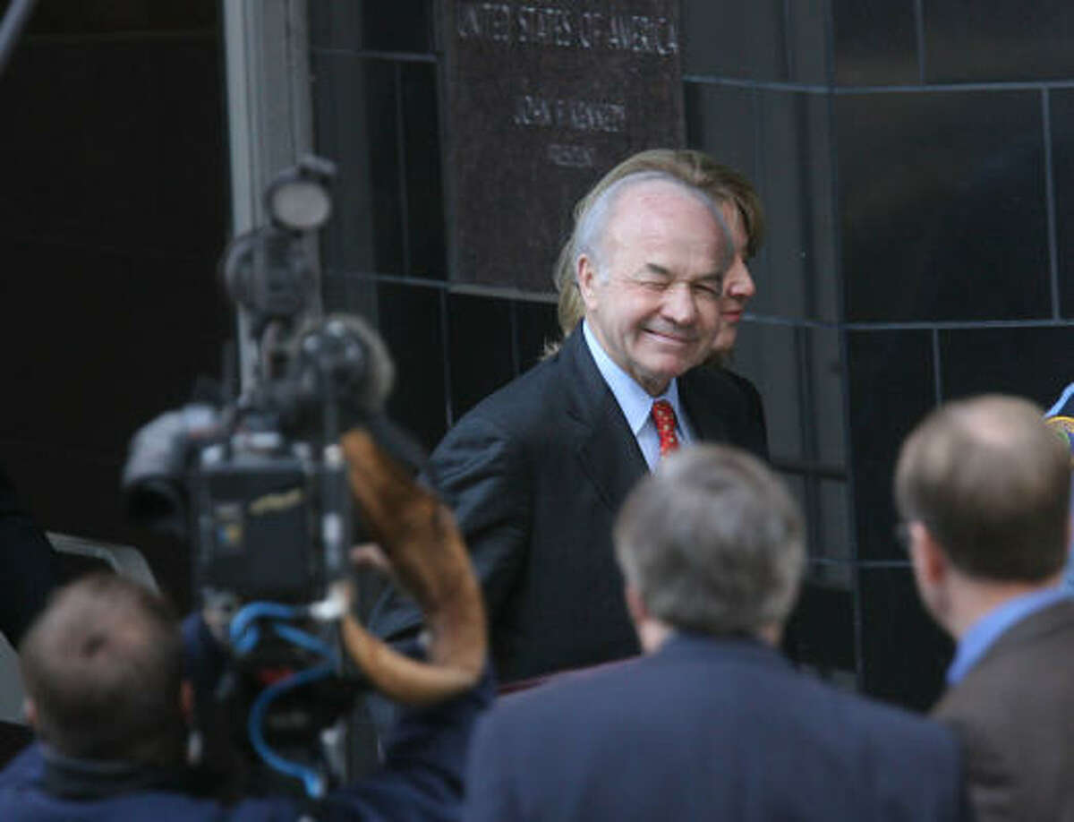 Ken Lay, former Enron chairman, winks at the media as he walks out court for a lunch break Thursday.