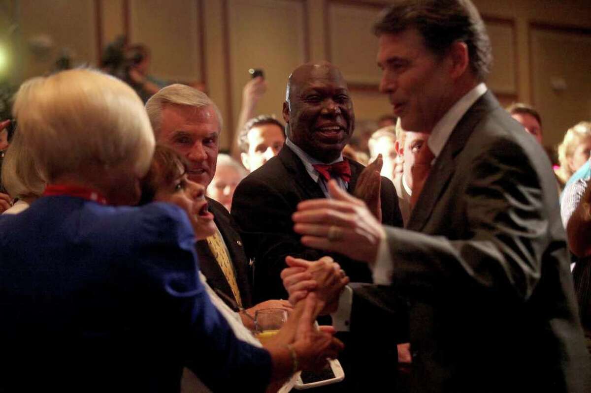 Michael Williams, former Chairman of the Railroad Commission of Texas and a candidate for U.S. Congress from Texas, center, watches as Governor Rick Perry greets supporters including Judy Crawford, of Atlanta, GA, left, upon entering the Carolina Ballroom to announce his run for President of the United States during the RedState Gathering at the Francis Marion Hotel in Charleston, SC on Saturday, August 13, 2011.