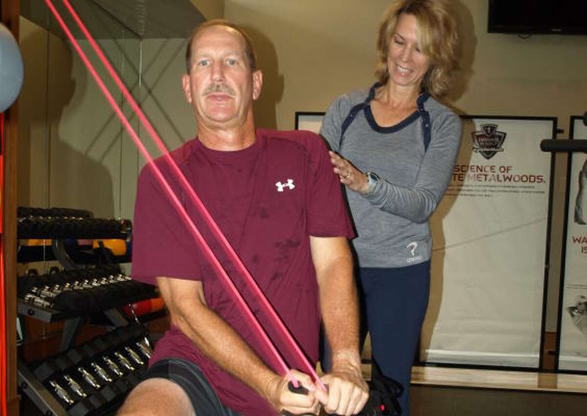 Pam Owens, the director of fitness for Redstone Golf, supervises Gary Janik's training session.