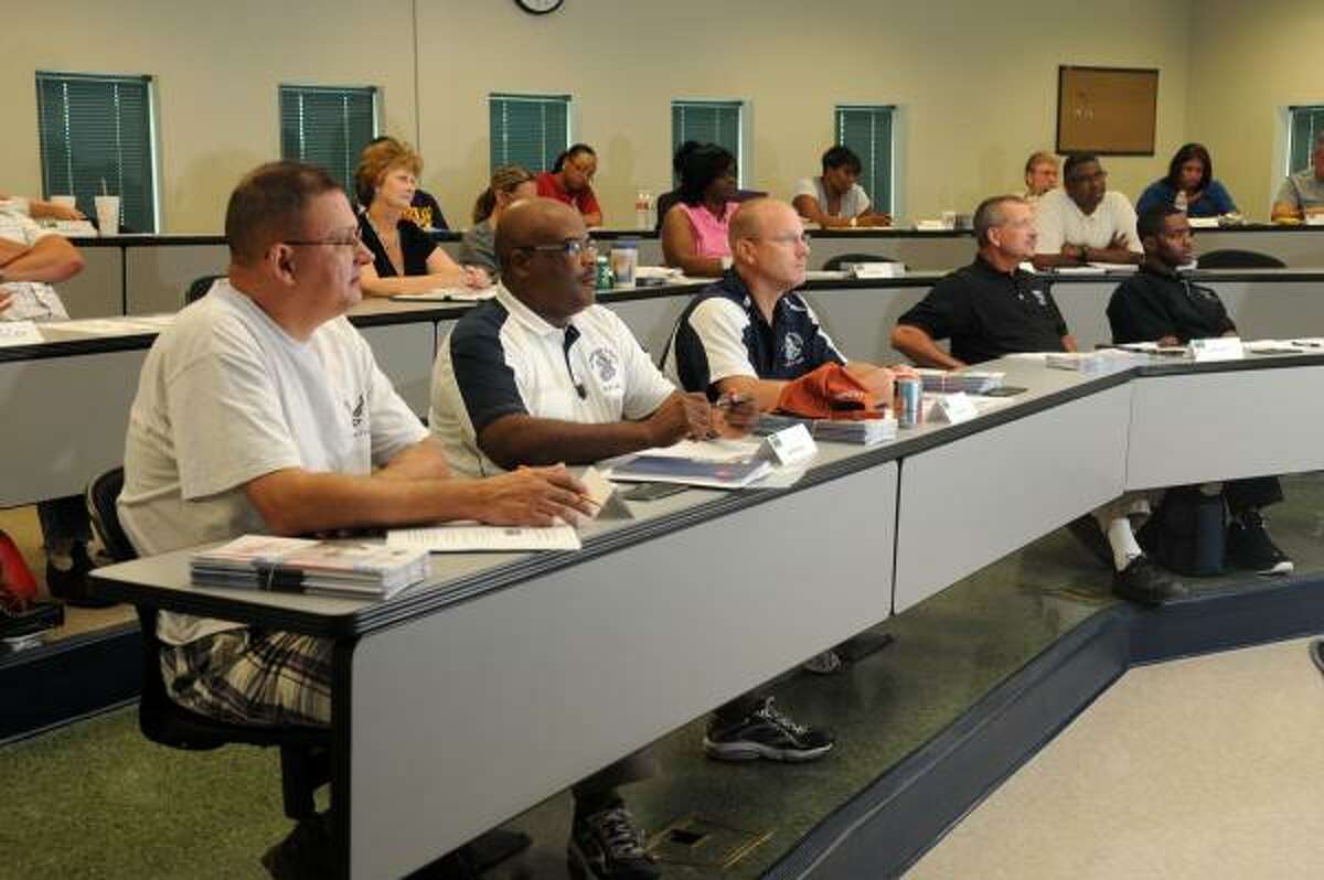 Scott Newberry, Damond Banks, Greg Boucher, Robert Rohm and David Watkins listen to Harris County Emergency Management Coordinator Mark Sloan during a CERT training class for Humble ISD staff members at the Harris County Fire and Sheriff Training Academy.