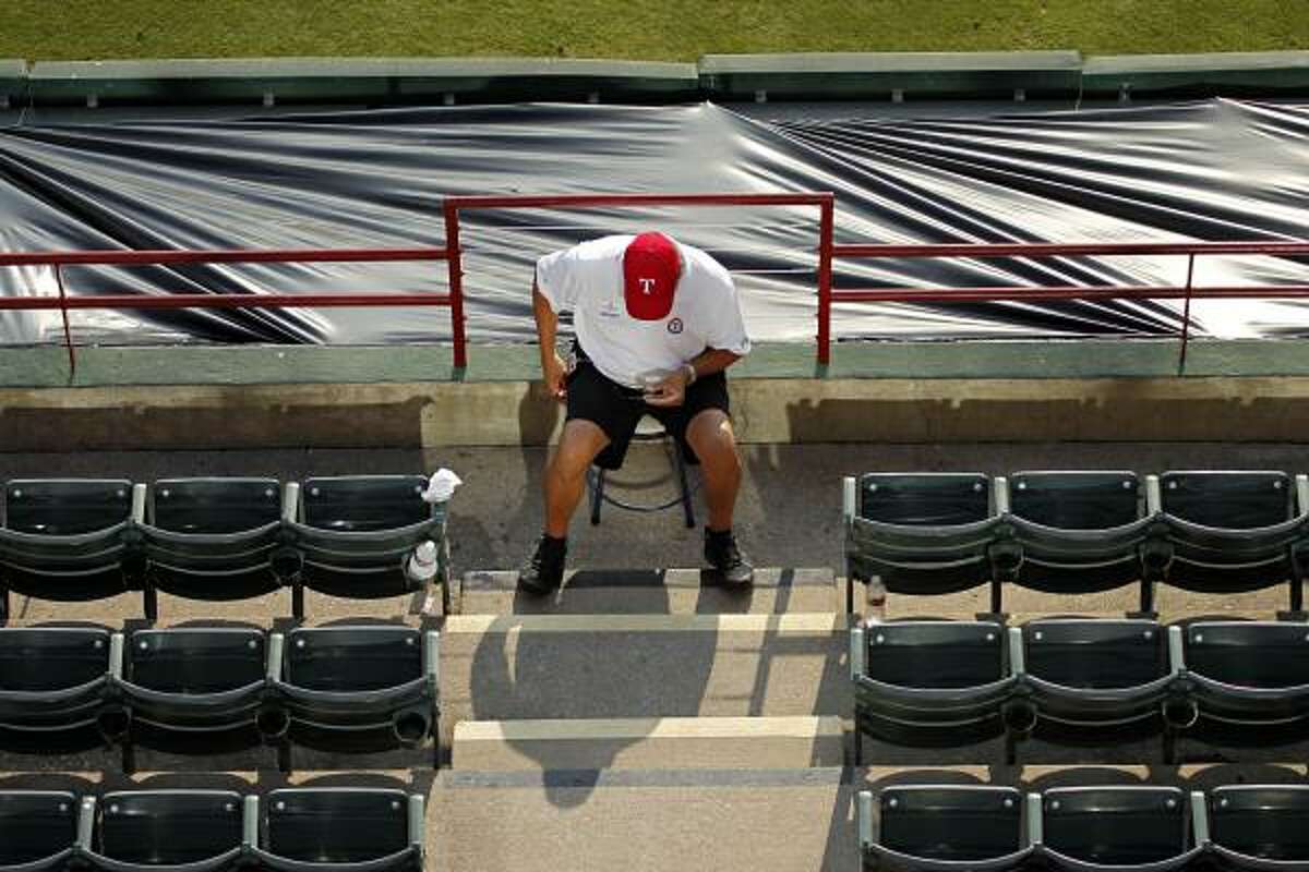 An event staff employee sits in front of the rail where Shannon Stone fell at Rangers Ballpark.