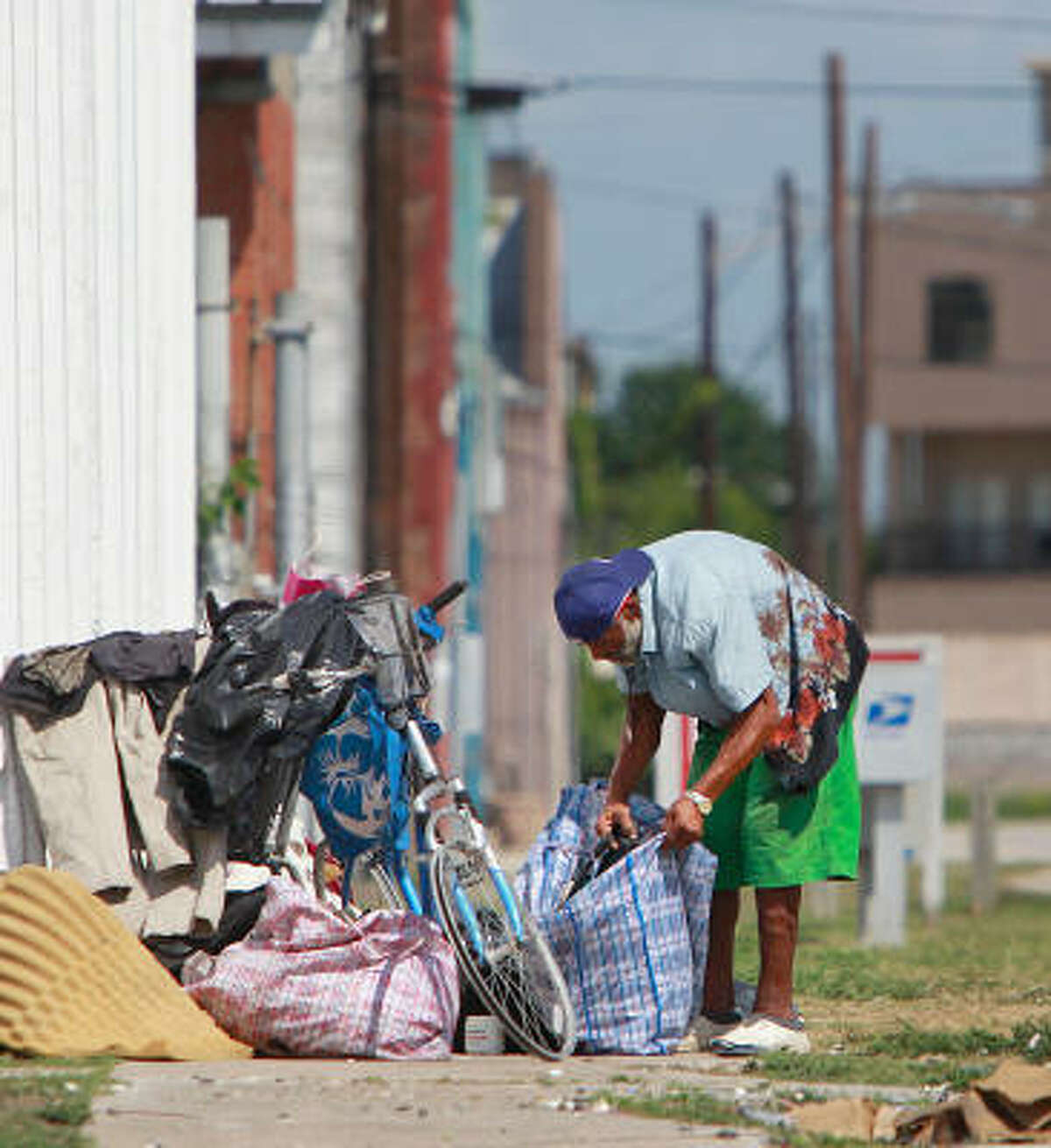 C.J. stows his belongings at a corner along St. Emmanuel and Congress on Wednesday. East Downtown residents have petitioned to have their neighborhood added to the city's anti-loitering ordinance, which prohibits sleeping on sidewalks.