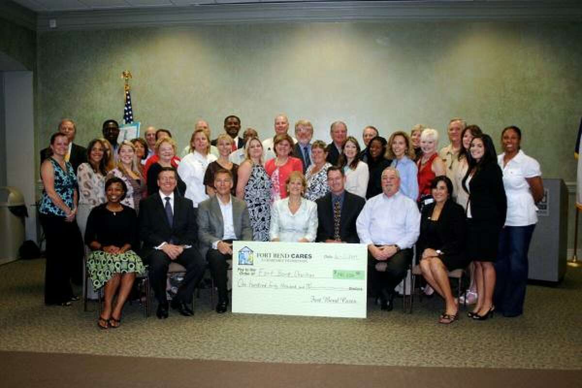 GROUP SHOT: The Fort Bend Cares Foundation expressed appreciation to 29 charitable organizations by awarding $140,000 in grants. Jill Curtis, seated center, holds the check. On either side of her are Fort Bend Cares Foundation board members. The happy award recipients are in the two rows behind her.