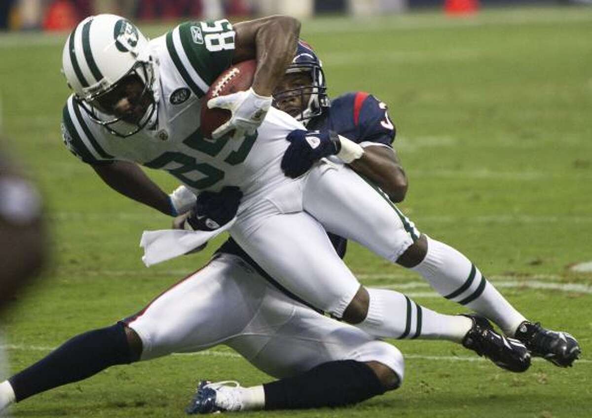 Jets wide receiver Derrick Mason (85) is stopped by Texans safety Danieal Manning during the first half.
