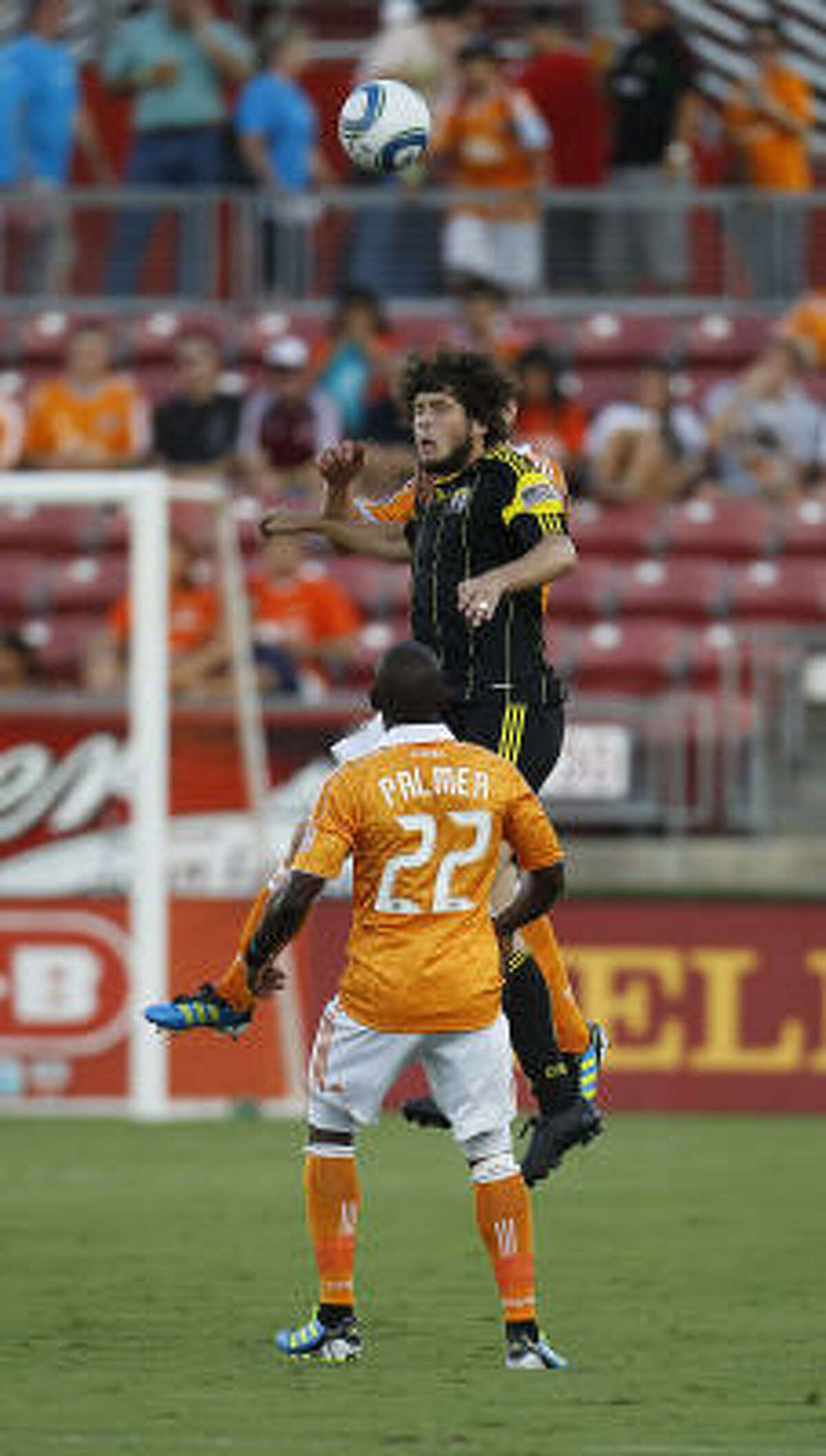 Columbus' Tommy Heinemann (32) goes up for the ball over Dynamo's Lovel Palmer (22) in the first half.