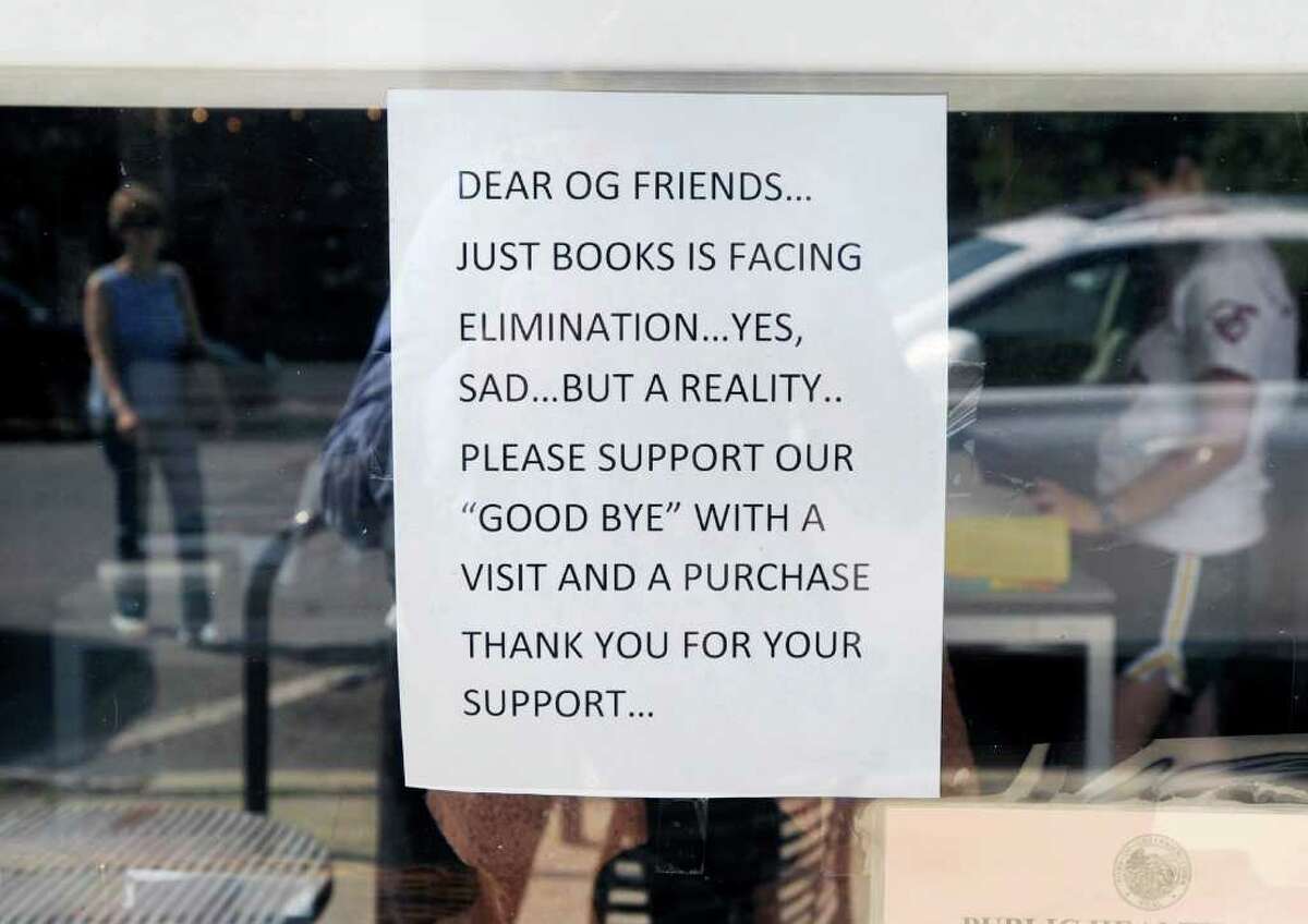 A sign in the window of Just Books at 28 Arcadia Road, Old Greenwich, Thursday afternoon, Aug. 18, 2011. The owner of the book store, Marion Boucher Holmes, says she will be closing the store due to a lack of business that she believes is occurring as customers increasingly eschew hard copies in favor of buying their books in a digital format.