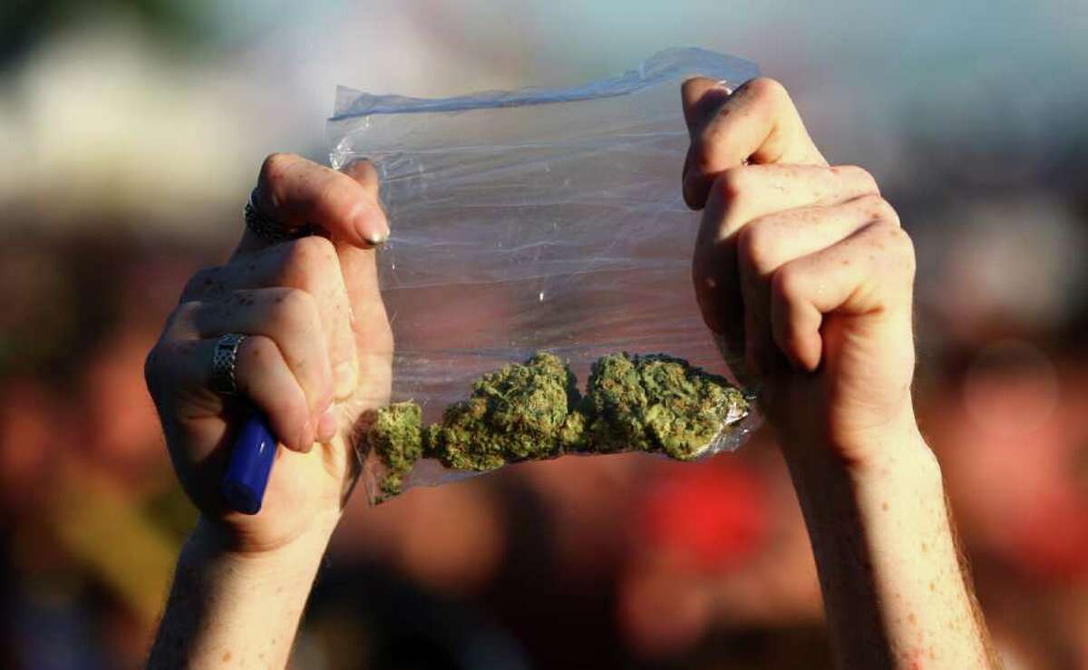 A participant holds up a bag of marijuana during the first day of Seattle's Hempfest 2011, a gathering of hundreds of thousands of people at Myrtle Edwards Park on Friday, August 19, 2011. The pro-pot festival is billed as the largest in the country and on Saturday will feature the Seattle mayor and U.S. Rep. Dennis Kucinich. This was the first year the festival spanned three days.
