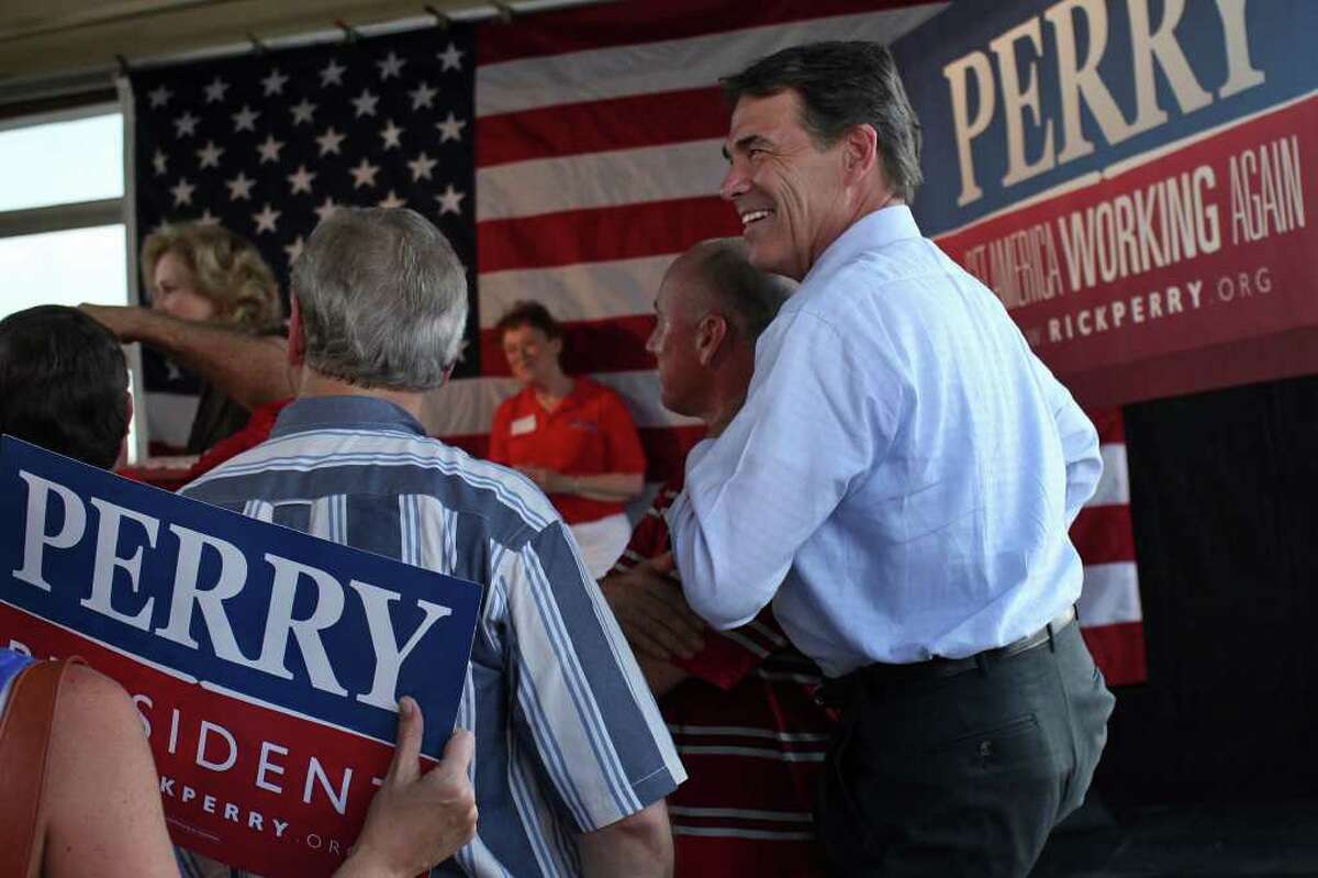 Governor Rick Perry takes in the applause as his wife, Anita, introduces him upon their arrival at the Rick Perry Welcome Home Rally at Abel's on the Lake in Austin, Aug. 20, 2011.